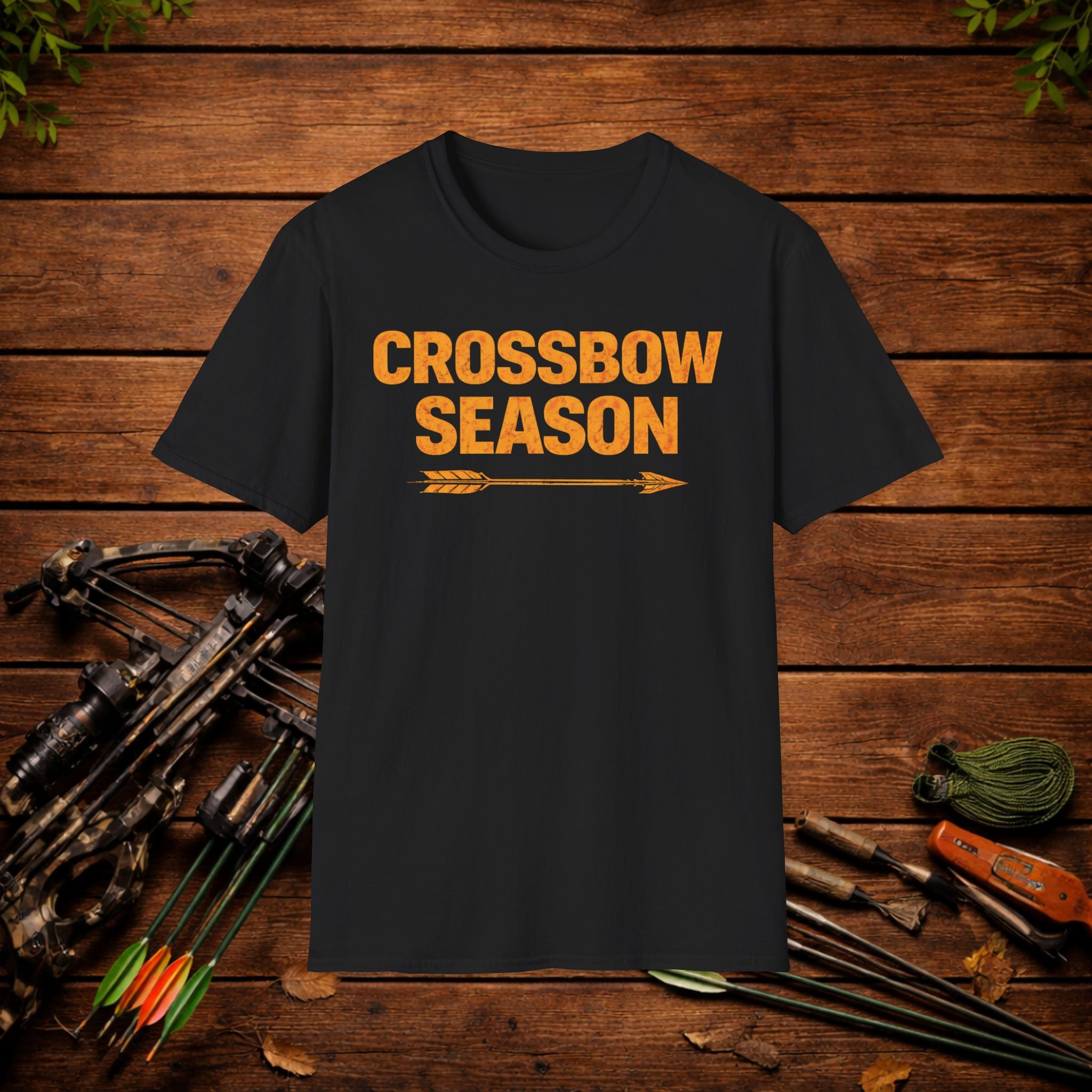 Black t-shirt with 'Crossbow Season' text on a wooden background with archery equipment.